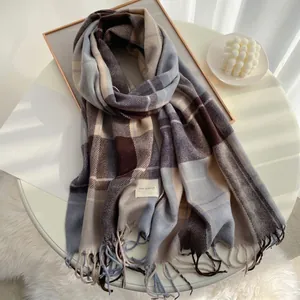 Detail of plaid scarf featuring soft cashmere-like fabric and decorative fringes