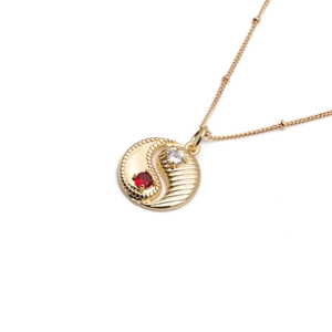 Detailed close-up of gold-plated Bagua pendant necklace with red and clear zircon stones