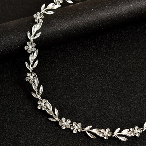 Détail d'un bandeau de mariée argenté avec feuilles de cristal et perles sur noir
