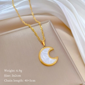 Detailed view of a gold crescent moon pendant with shell inlay on a silk display