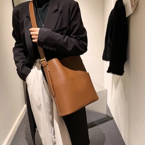 Braune Leder-Beuteltasche mit großem Fassungsvermögen und breitem Schultergurt am Model