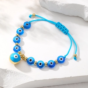Detail view of handmade Bohemian beaded bracelet with blue evil eye charms and gold beads