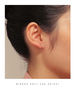 Macro detail of cross stud earrings featuring brilliant white cubic zirconia pavé stones