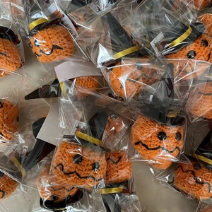 Macro shot of multiple handmade crochet Halloween pumpkins with black wizard hats
