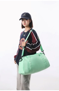 Asian female model carrying a mint green lightweight sports gym duffel bag for travel