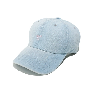 Detailed view of pink bow embroidery on light blue denim baseball cap for women