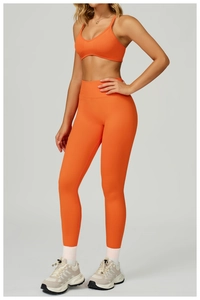 Détail d'un ensemble de yoga orange sans couture avec brassière et legging de sport