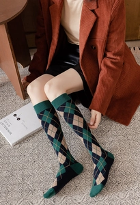 Close-up of argyle knee-high socks in dark green and navy blue with knit texture