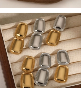 Polierte geometrische Würfelohrringe in Gold und Silber auf Samt-Schmuckdisplay