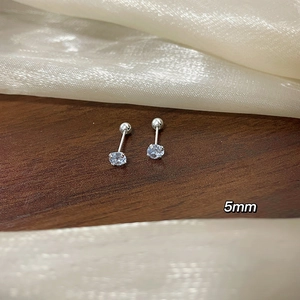 Close-up of 5mm light blue zircon stud earring with screw-back on dark wood and silk