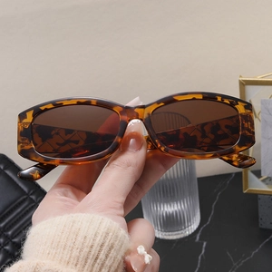 Close-up of stylish tortoiseshell rectangle sunglasses with brown lenses on a desk