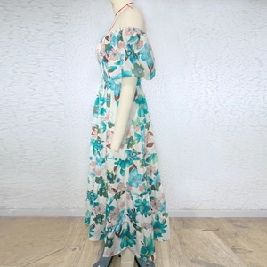 Detail of off-shoulder puff sleeves and floral pattern on a summer tiered maxi dress