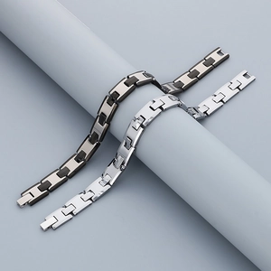 Polished H-shaped link bracelet in black and silver finishes on a studio pedestal