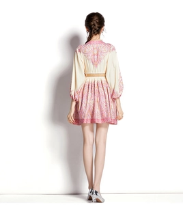 Back view of bohemian mini dress featuring lantern sleeves and paisley print design
