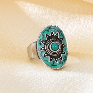Detailed close-up of large oval turquoise ring with sunburst pattern on silk background