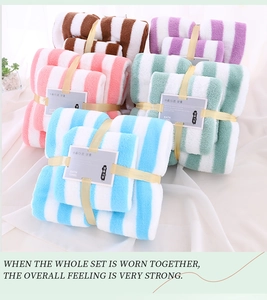 Stack of striped coral fleece towel sets with ribbons in brown pink green blue and purple
