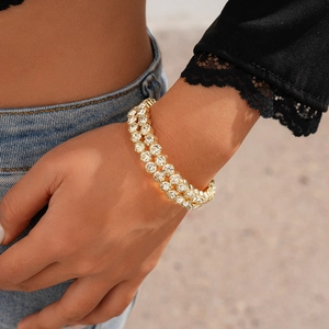 Close-up of double-layered gold bracelet with paved crystals on female model