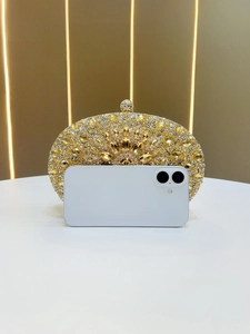 Golden rhinestone evening bag shown next to a smartphone for size reference and scale