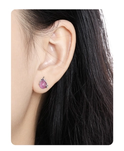 Close-up of elegant S925 silver earring featuring a purple teardrop crystal on earlobe