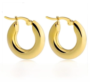 Close-up of thick gold-plated titanium steel hoop earrings with polished finish