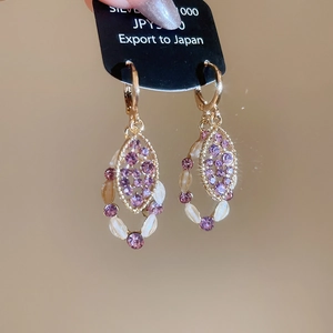 Detailed view of vintage gold earrings with purple crystals and s925 silver hooks