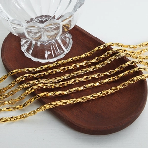 Elegant gold-plated chain necklace set displayed on an oval wooden tray with glass decor