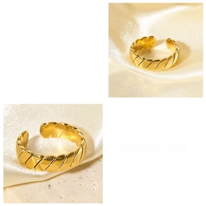 Macro detail of golden twisted texture and polished surface on an adjustable open ring
