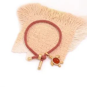 Pink woven turtle bracelet with red natural stone and gold sea turtle pendant