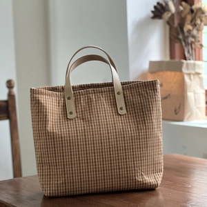 Retro brown checkered canvas tote bag with sturdy leather handles and metal rivets
