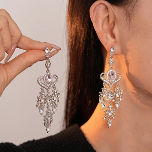 Eleganti orecchini vintage a nappa a cuore con strass rosa mostrati su una modella