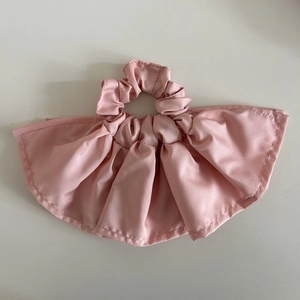 Detailed view of pink double-layered silk scrunchie with elegant ruffled design