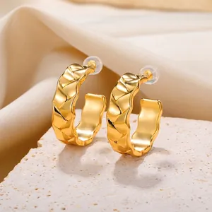 Fashionable golden C-shaped hoop earrings with textured geometric wave patterns for women