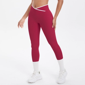 Détail du legging de yoga bordeaux avec taille croisée et liseré blanc décoratif