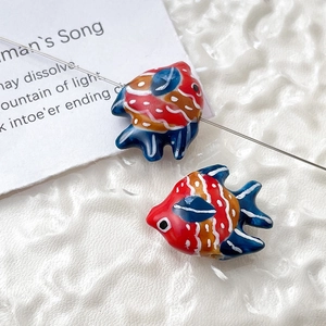 Macro shot of colorful ceramic goldfish beads for DIY jewelry with detailed patterns