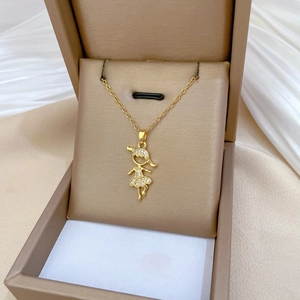 Luxurious gold girl pendant necklace with pavé diamonds on silk background