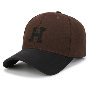 Close-up of the two-tone wool baseball cap with an embroidered H and premium texture