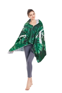 Detail of hooded microfiber beach towel featuring tropical green leaves and geometric patterns