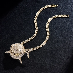 Close-up of golden Cuban tennis chain with iced-out shark pendant and rhinestones