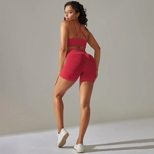 Detail eines burgunderroten Yoga-Sets mit überkreuztem Sport-BH und hoher Taille-Shorts
