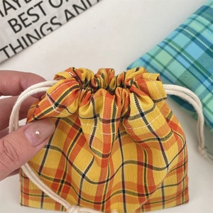 Detail of yellow plaid drawstring bag made of thick cotton canvas showing double cotton cords