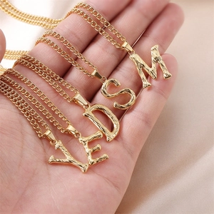 Textured gold letter pendants with V E D S M initials on delicate chains for women