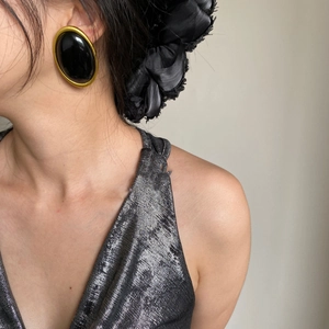 Vintage oversized oval earrings with black resin and gold frame on model view