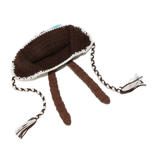 Detail of handmade crochet knit aviator hat featuring brown texture and tassel ties