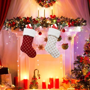 Detailed view of red and white plaid Christmas stockings with plush cuffs on a cozy fireplace