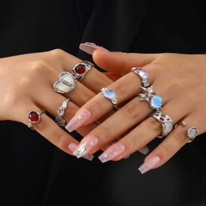 Gothic silver rings set with colorful gemstones worn by model on a dark background
