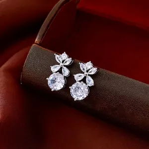 Orecchini a lobo a fiore in argento con zirconi su un supporto di lusso in pelle