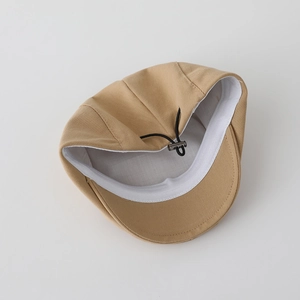 Detail of khaki twill cotton beret featuring adjustable elastic drawstring and metal buckle