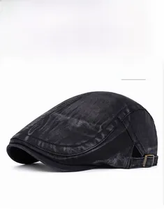 Detail of vintage washed black cotton flat cap showing metal buckle and retro texture