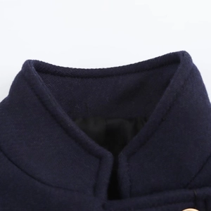 Macro detail of navy blue stand collar and fine stitching texture on the wool coat