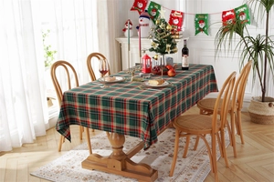 Festive red and green plaid tablecloth set on a wooden table in a Christmas setting